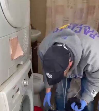 השוטר מבצע חיפוש במכונת הכביסה