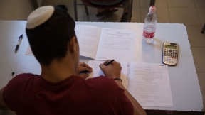 תלמיד תיכון מבצע בחינת בגרות
