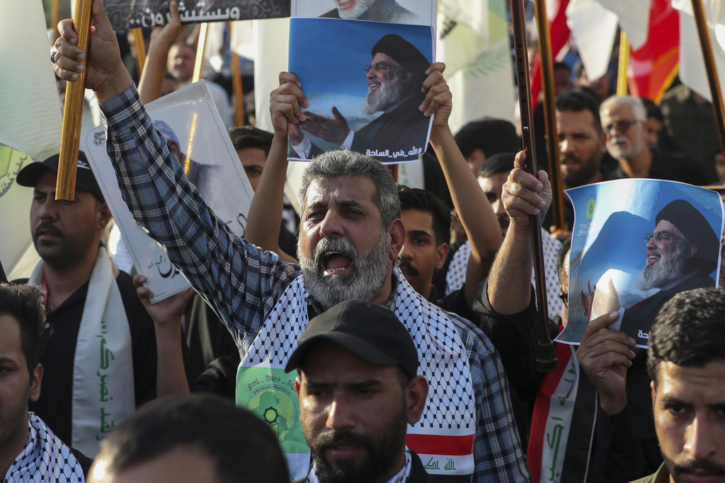 אזרחים שיעים בעיראק נושאים תמונות של נסראללה אחרי חיסולו, ספטמבר 2024