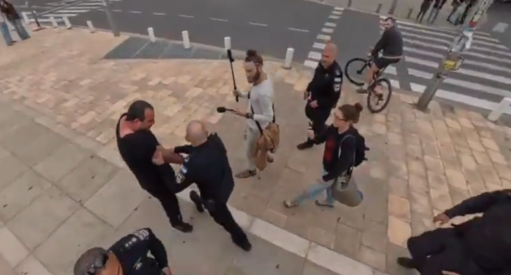 תומך הממשלה רועי סטאר (במרכז) והאדם שסייעה למפגינה ונעצר (משמאל)