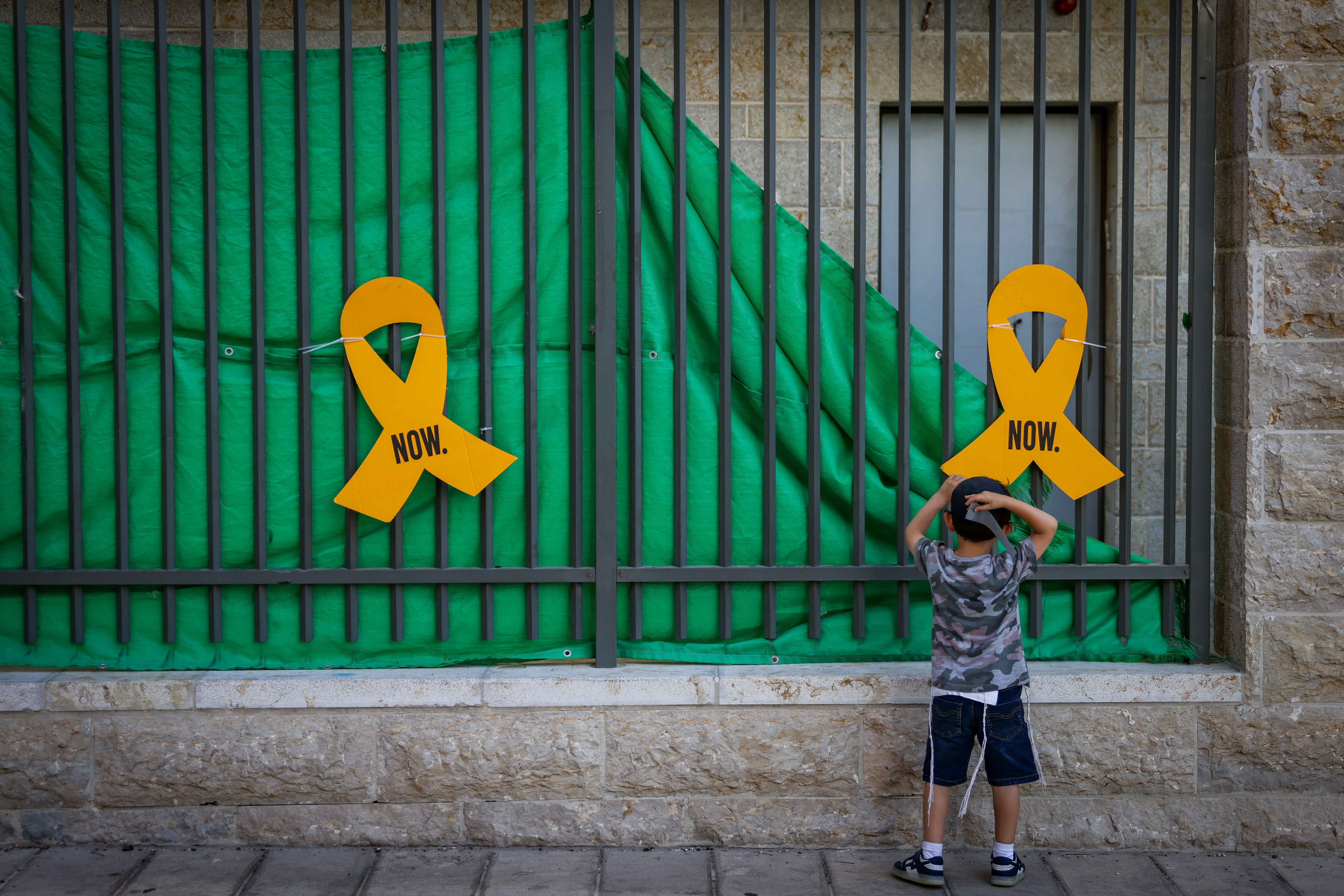 ילד מסתכל על הסרט הצהוב למען השבת החטופים