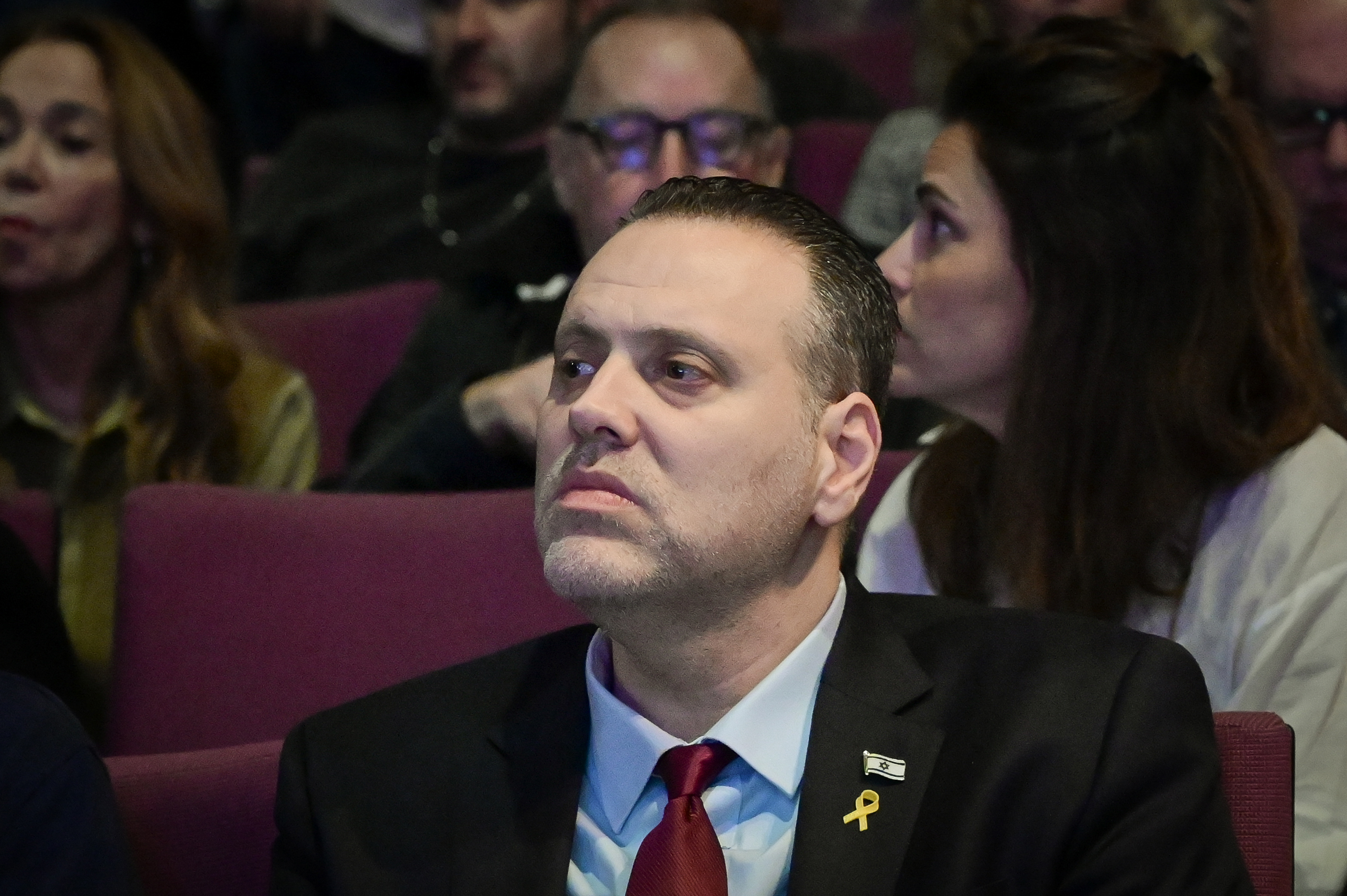 השר מיקי זוהר יושב באולם באירוע לזכרו של יעקב כהן