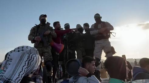 חמושים מגדודי עז א-דין אל-קאסם לצד עקורים ששבו לצפון הרצועה