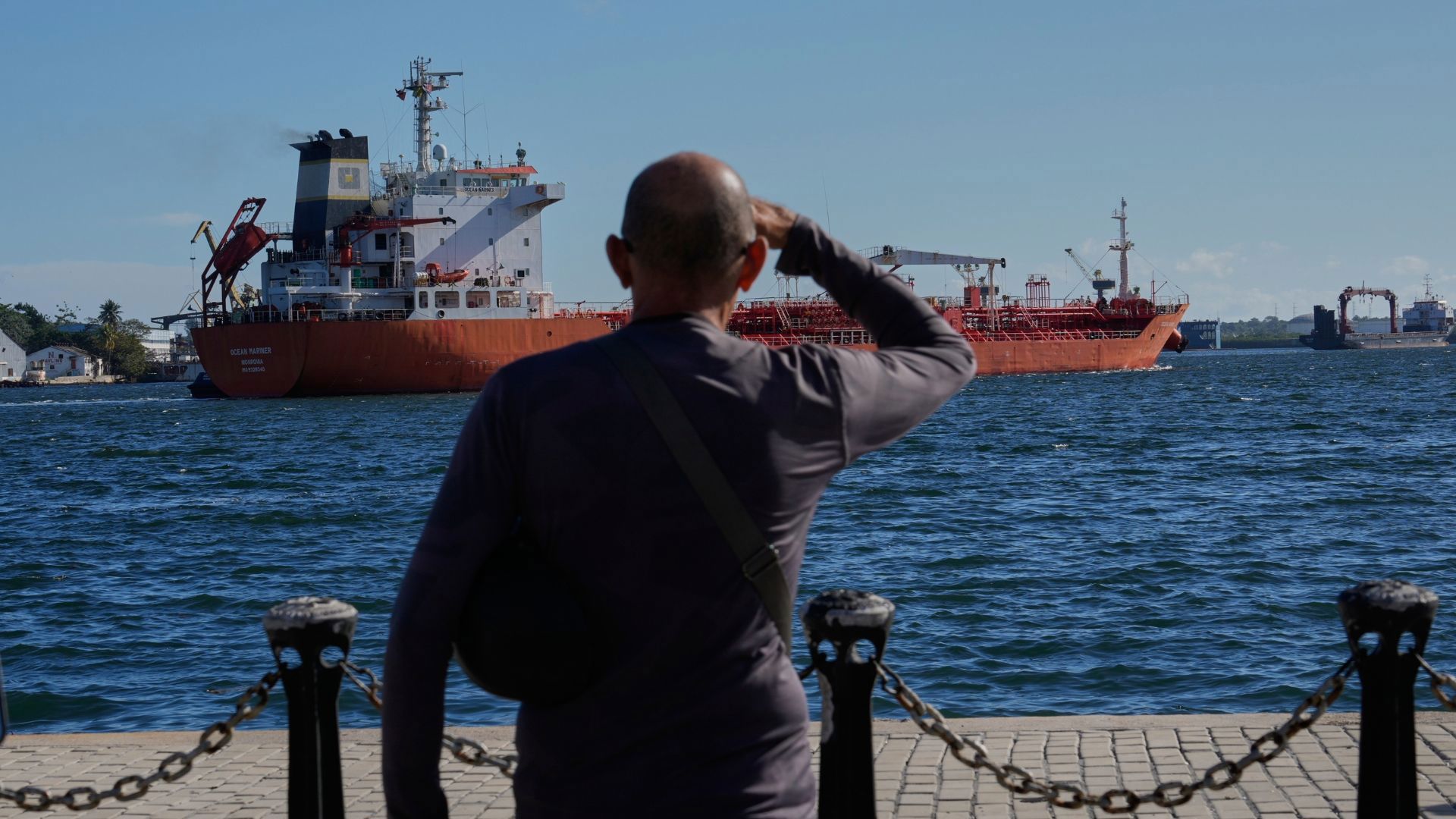 אדם צופה במכלית נפט מגיעה למפרץ הוואנה, מוקדם יותר החודש