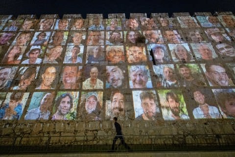 קיר תמונות החטופים על רקע חומות בירושלים - ישראל במלחמה - 07.11.23